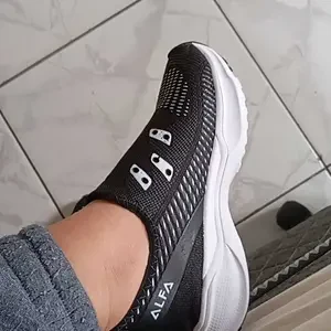 Tênis preto no pé sobre piso claro